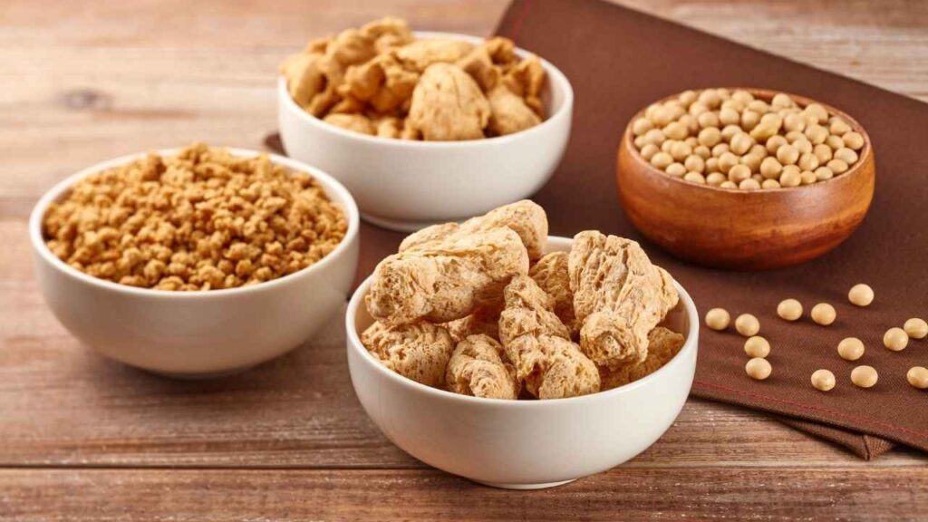 Soy-based plant-based protein sources including textured soy protein, walnuts, peanuts and soybeans in bowls