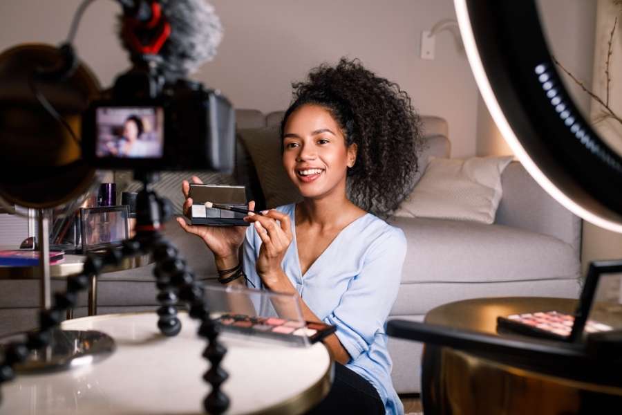 Professional content creator filming makeup tutorial to measure and improve influencer marketing ROI metrics