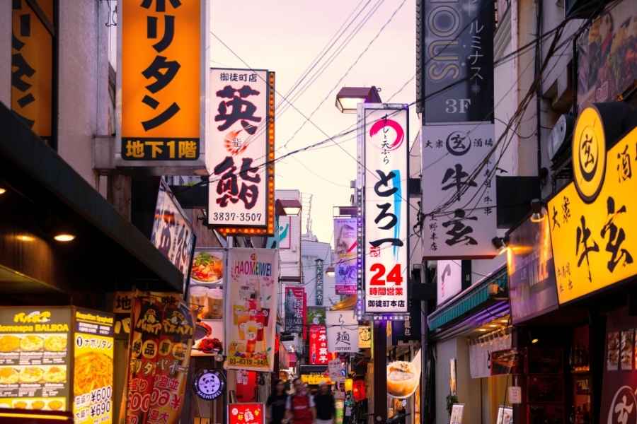 A narrow alleyway in Japan lined with numerous vibrant neon signs, a popular subject for Street Photography.