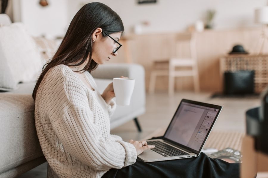A woman sitting on the floor while checking an online AI content detection guide.